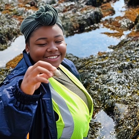 An Ignite fellow examining a shell they picked up in Acadia National Park.